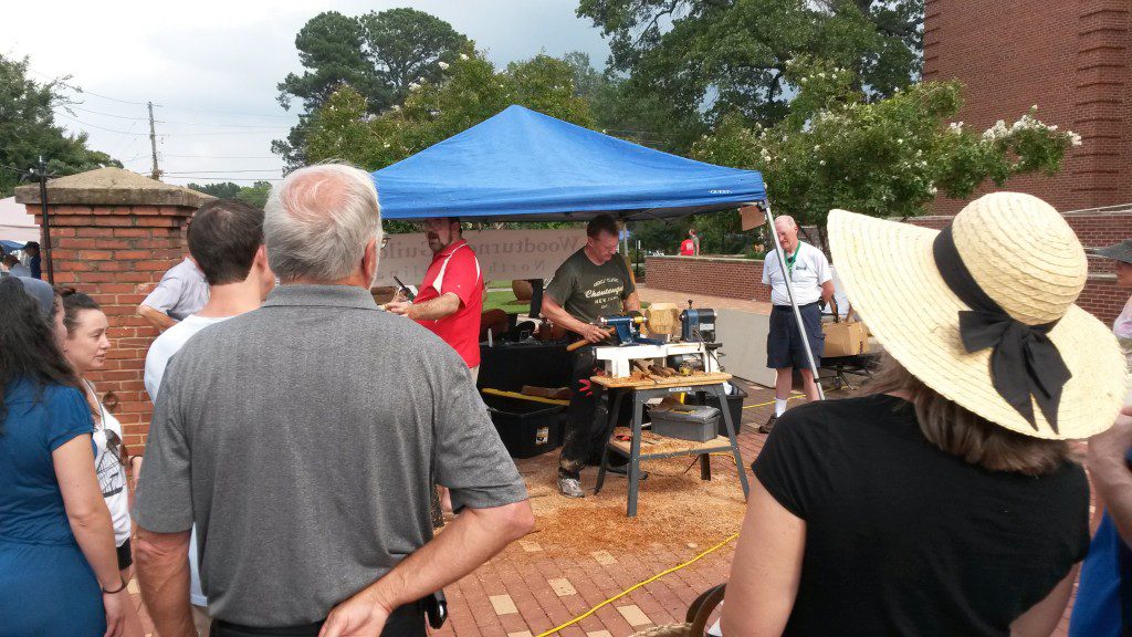 People watching a woodworker at work